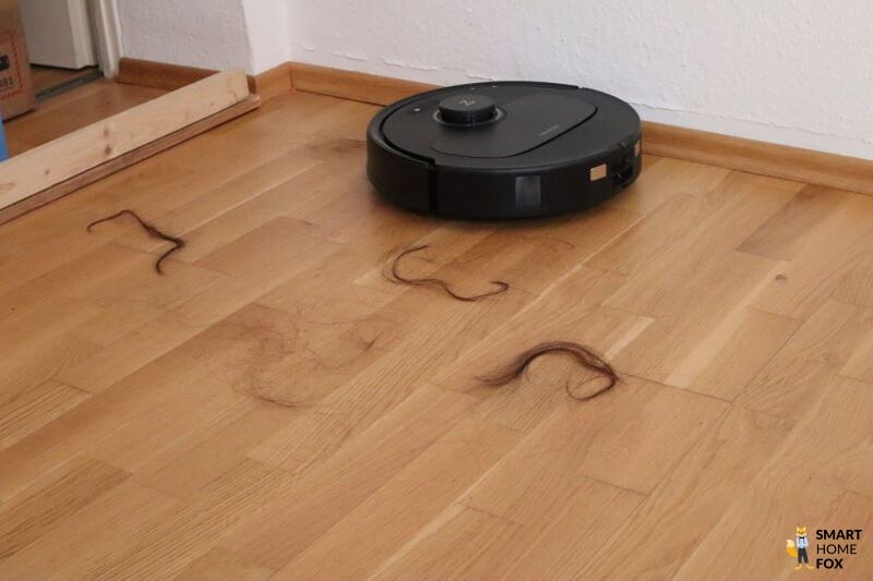 Haare liegen vor dem Roborock Q Revo Plus auf dem Parkett